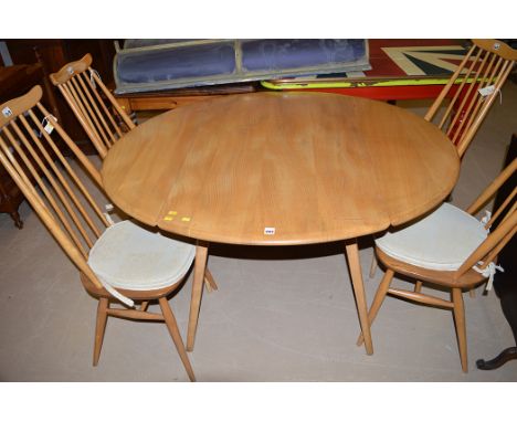 An Ercol style elm drop leaf dining table, 124cms wide; and four similar spindle back dining chairs.