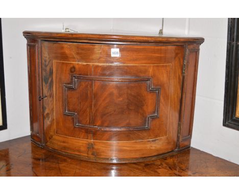 A 19th Century bowfront corner cupboard, the door opening to reveal a shelf, 65cms wide.