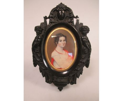 An oval portrait miniature of a lady in white wearing a coral bead necklace, in a carved hardwood frame 12cm including frame 