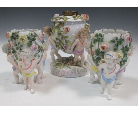 A pair of Plaue on Havel putto supported egg vases and an oil lamp, tallest 25cm  