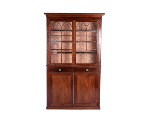 A VICTORIAN MAHOGANY BOOKCASE CABINET In two parts, the outswept cornice above a pair of astragal glazed doors enclosing thre