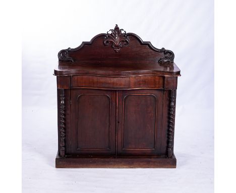 A VICTORIAN MAHOGANY CHIFFONIER The serpentine top surmounted by a moulded and scroll-carved back gallery, a conforming friez