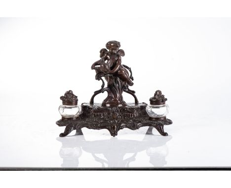 AN ART NOUVEAU INKWELL, LATE 19TH CENTURY Designed by N. Vidal, the two glass inkwells flanking a seated putto holding a bird