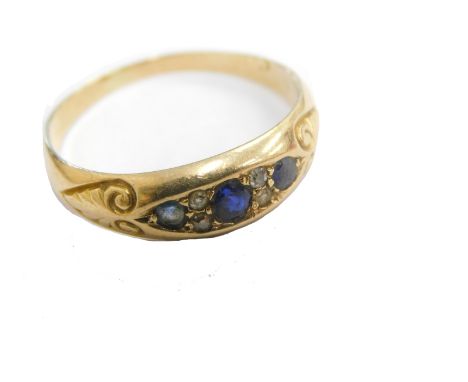 A gypsy ring, of elaborate scroll design, set with small blue and white stones, unmarked, size R.