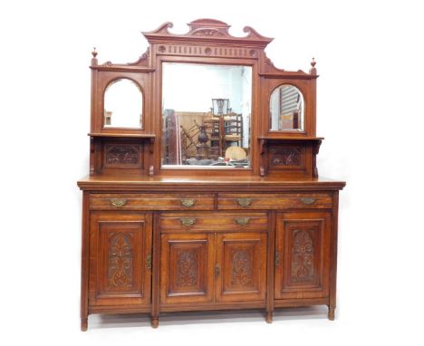 A 19thC oak and walnut mirror back sideboard, of large proportion, with a fixed carved scroll, floral and fruit cornice above
