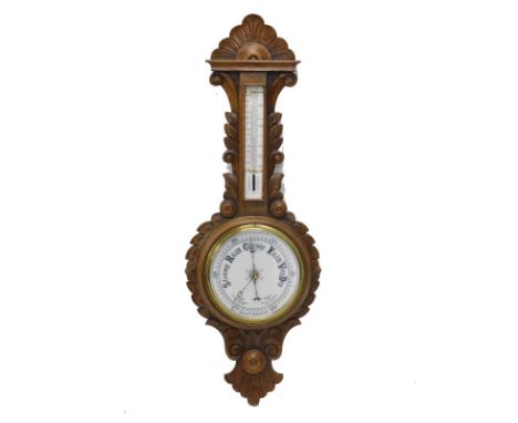 A 20thC oak cased banjo barometer, the 20cm main dial marked Rises for Dry, surmounted by a thermometer, in a heavily carved 