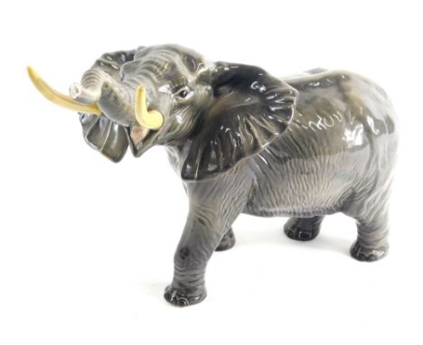 A Beswick pottery figure of an elephant, trunk raised, printed marks beneath, 29cm high. (AF) 