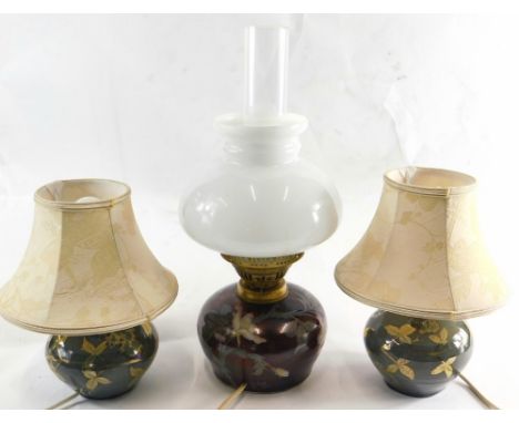 Three Jonathan Chiswell Jones studio pottery lustre lamps, comprising a pair of table lamps in green and an oil lamp in red l