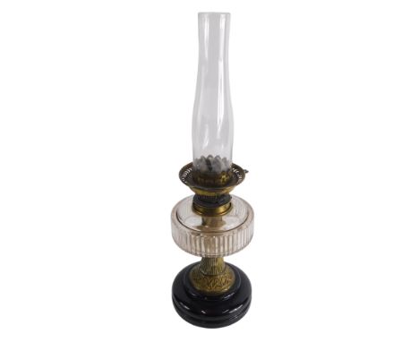 An early 20thC oil lamp, with clear glass reservoir and plain glass funnel, 22cm high.