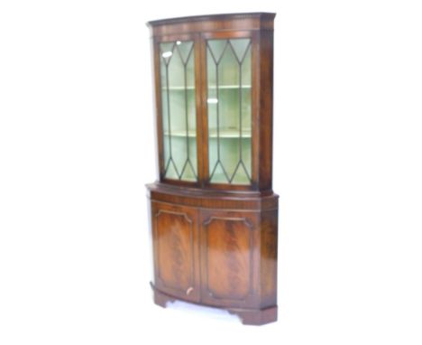 A late 20thC mahogany freestanding corner cabinet, the dentil top raised above a pair of astragal glazed doors revealing fixe