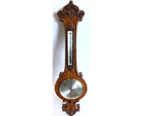Pastorelli and Co of London. A Victorian walnut wheel barometer, the case carved with scrolls, leaves, etc., with silvered th
