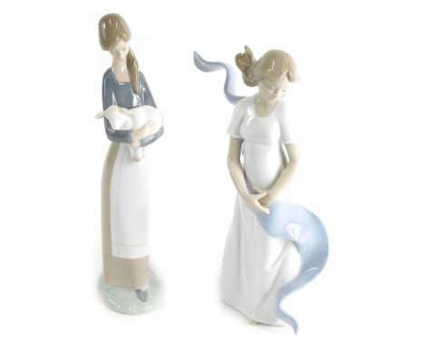 Two various Lladro figures, girl holding lamb, 29cm high, and a Nao figure La Caricia Del Viento of girl in flowing robes. (2