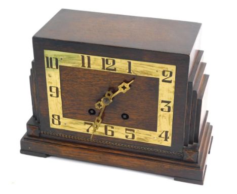 A mid 20thC Art Deco oak cased mantel clock, with brass pierced numerals, with stepped sides, on rectangular base, with eight