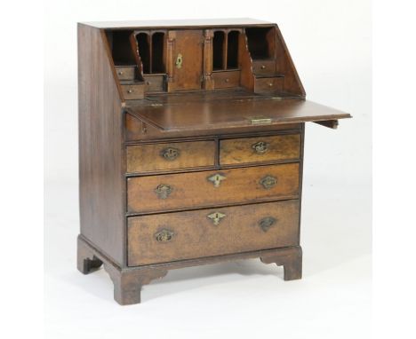 Early Georgian oak bureau of small proportions, early 18th Century with later restoration, having a stepped fitted interior w