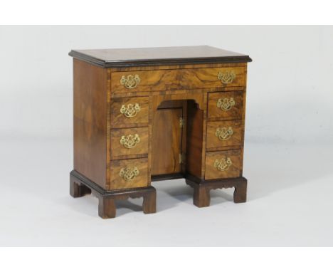 Walnut kneehole dressing table in Georgian style, quarter veneered top with broad crossbanding over a long frieze drawer and 