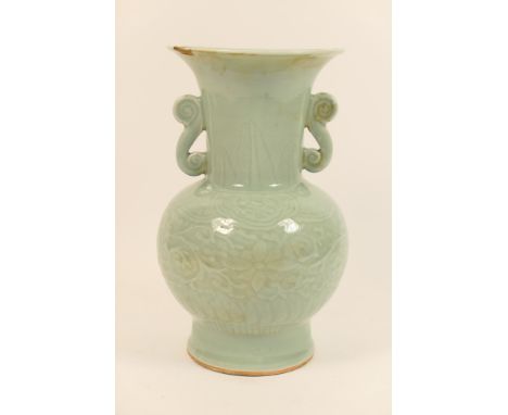 Chinese carved celadon vase, having a trumpet neck with scroll handles, over a baluster body worked with scrolling foliage, t