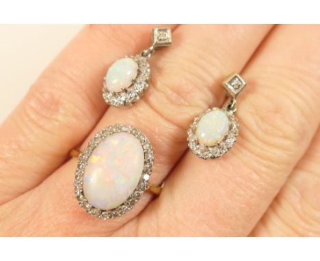 Suite of opal and diamond jewellery, comprising ring centred with a cabochon opal, approx. 13mm x 9mm, bordered with tiny bri