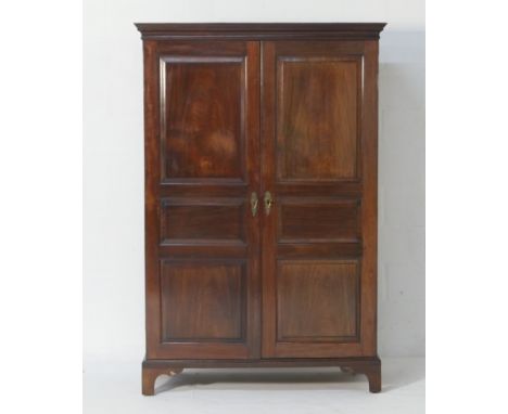 Edwardian mahogany wardrobe, having a cavetto moulded cornice over two triple fielded panel doors, opening to a single hangin