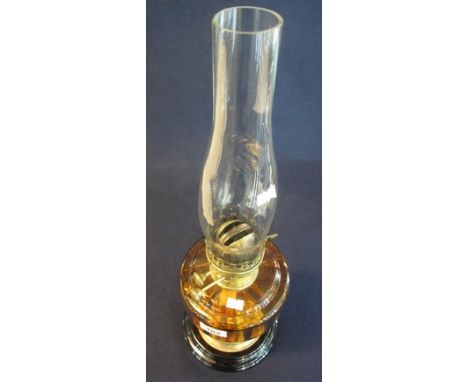 Early 20th Century brass double burner oil lamp with amber glass reservoir on brass pedestal with ceramic base and clear shad