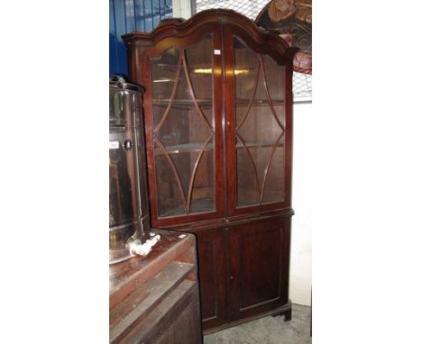 Early 19th Century mahogany two stage corner cabinet, having shaped moulded cornice, above two astragal glazed doors, the int