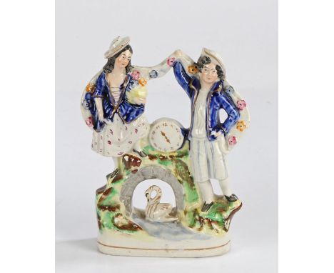 Victorian Staffordshire clock figure group, with figures either side of a clock face and a swan below, 19.5cm high