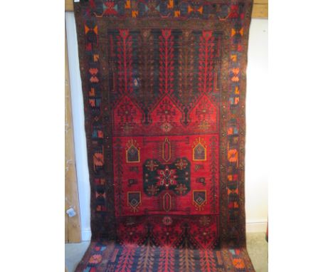 A Baluchi red ground hand woven woollen rug, approx 336cm x 160cm - in general good condition but with a small repaired patch