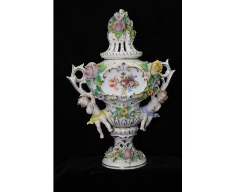 A German porcelain two handled pot pourri vase, ogee form applied with cherubs and summer flowers about the transfer printed 