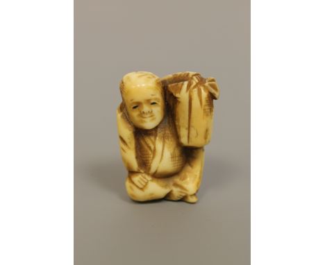 A Japanese ivory netsuke depicting a seated gentleman, Meiji period