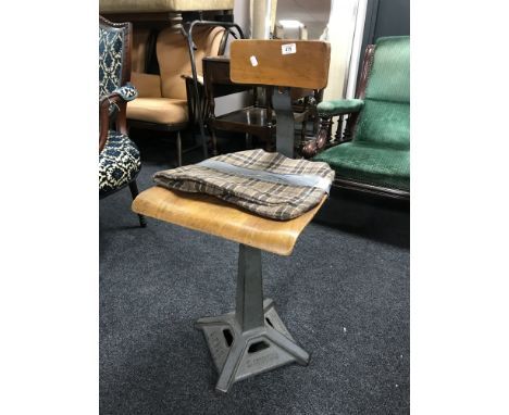 A mid 20th century Singer machinist's chair  CONDITION REPORT: This chair has a taped patch to the seat and more tape securin