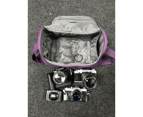 An Olympus OM1 camera with lens, an Olympus OM30 with lens, an Olympus OM40 camera with lens and an Olympus automatic camera 