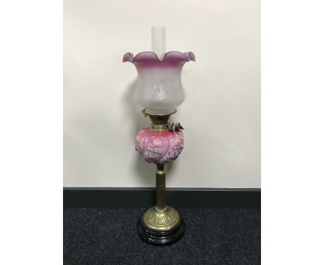 An early 20th century brass oil lamp with pink glass shade 