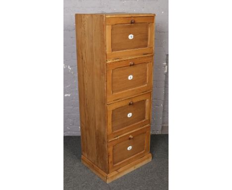 A vintage pine bank of four filing drawers with enamelled letter plates. 156cm tall x 59cm wide.  Originally part of a larger