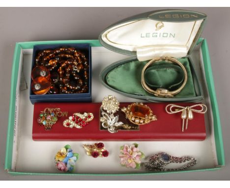 A tray of vintage costume jewellery including coloured paste brooches, boxed Legion bracelet watch and amber effect pieces et