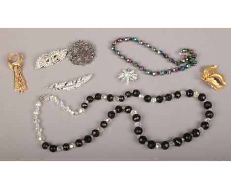 A collection of vintage costume jewellery including aurora borealis beads, Art Deco paste clip, gilt leaf brooch and a tassel