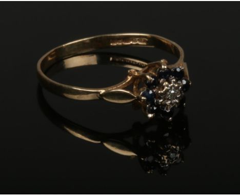 A 9ct gold sapphire and diamond daisy cluster ring. Size P.  