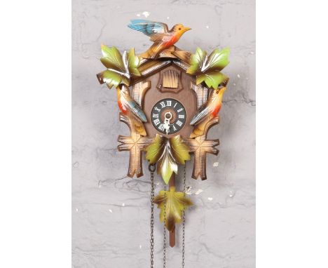 Hubert Herr carved wood black forest cuckoo clock with a carved bird pediment, two pine cone weights, 27cm high with original