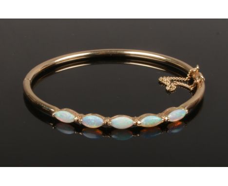 A 9ct gold five stone opal bangle. 6.5 grams gross weight.  