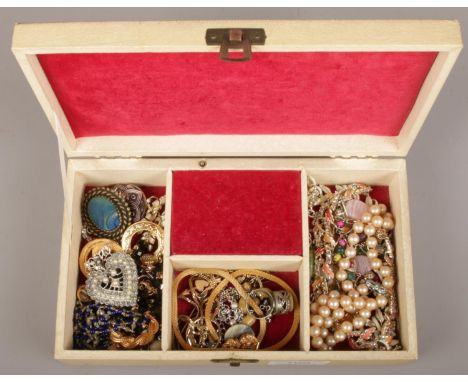 A vintage musical jewellery box containing vintage costume jewellery, necklaces, dress clips etc.  