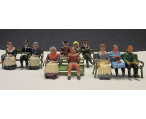 Britains and other: eleven seated figures, and three Britains green park benches, and one other bench  