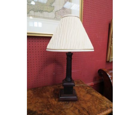 A wooden column-form table lamp with cream pleated shade 