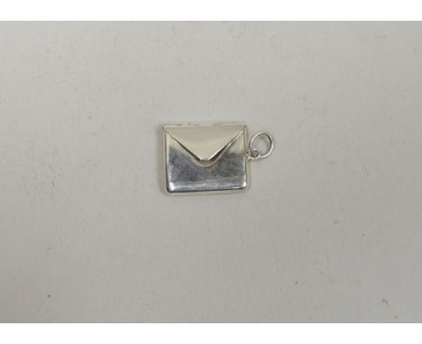 A silver stamp case in the form of a letter, marked 925, approximately 2.5cm x 2.5cm