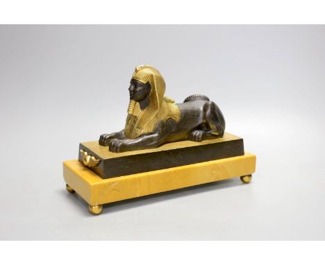 A parcel gilt bronze model of a sphinx on a Siena marble base - 22cm long