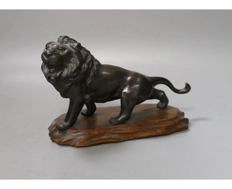 A Japanese bronze model of a lion, Meiji period, signed tablet to underside of torso. 22cm long