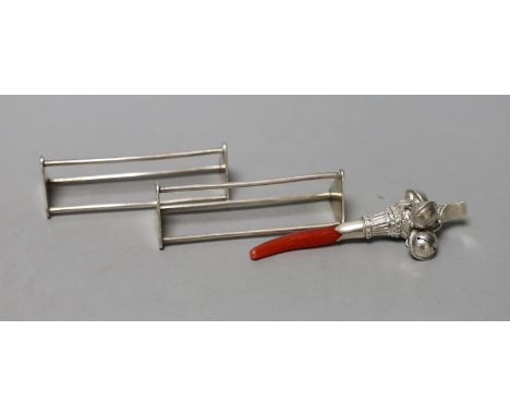 A white metal and coral mounted child's rattle, 81mm together with a pair of George III silver triangular knife rests, John E