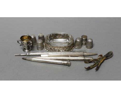 An Edwardian repousse silver mounted glass salt,69mm, a small silver tri-handled trophy cup,  five silver thimbles, a plated 