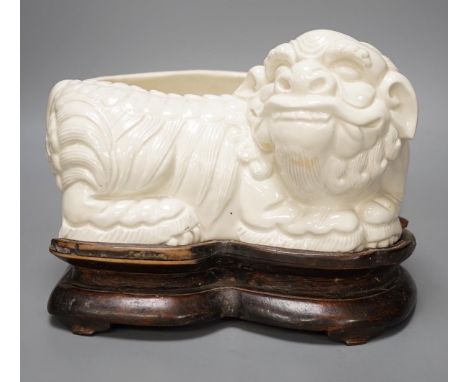 A Chinese cream glazed lion’dog planter on hardwood stand, 21cm