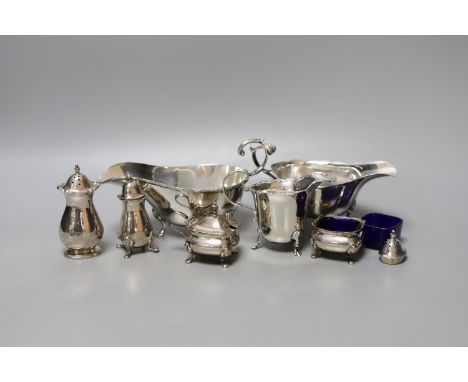 Two George V silver sauceboats, one a.f., a silver cream jug, four silver condiments, a lid and blue glass liner.