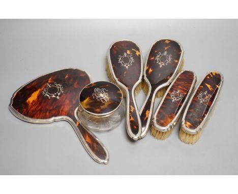 A George V silver and tortoiseshell mounted mirror and brush set, Birmingham, 1928 and a similar powder jar.