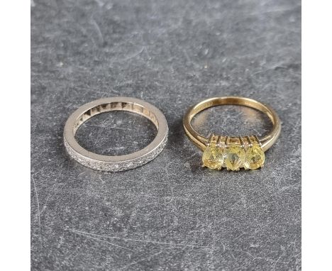 A diamond eternity ring, size N; together with a 9ct gold ring, set three pear shaped green stones and four small diamonds, s