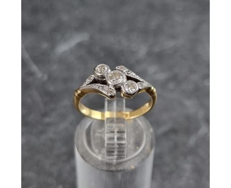 A yellow metal diamond three stone crossover ring, stamped 18ct, size M 1/2.